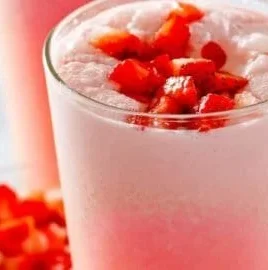 Starbucks Pink Drink in a clear cup with strawberries and coconut milk