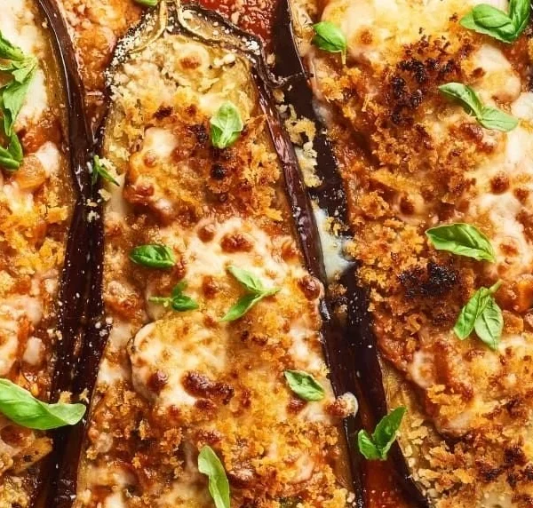 Delicious stuffed eggplant parmesan dish topped with melted cheese and herbs.